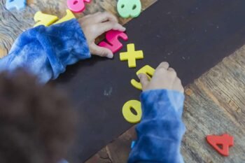 Ethnic boy solving mathematical example made of toy numbers